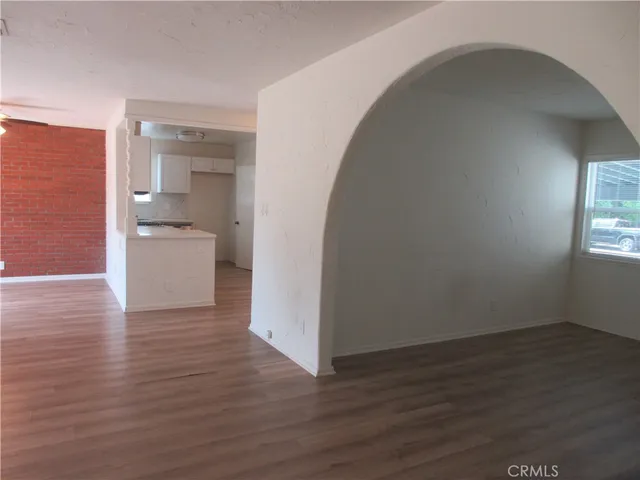 a view of a room with wooden floor and a bathroom