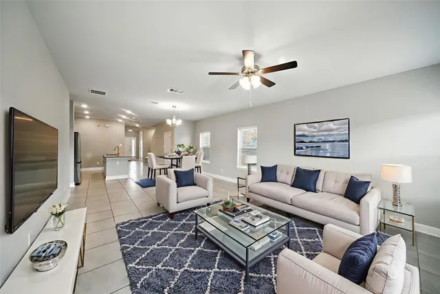 a living room with furniture a rug and a flat screen tv