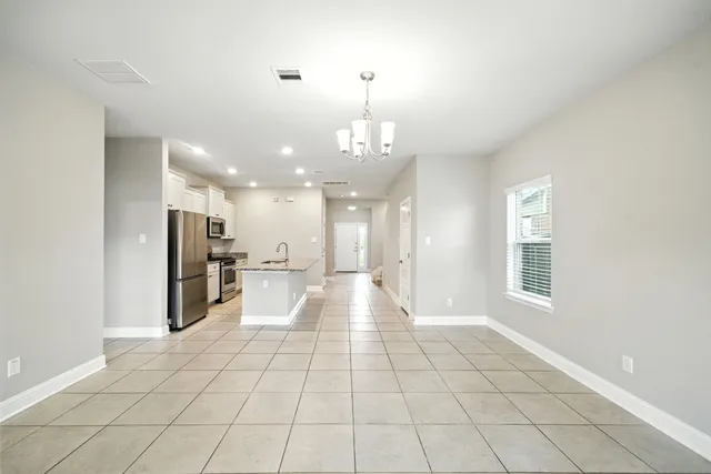 a view of a hallway with wooden floor and a large mirror