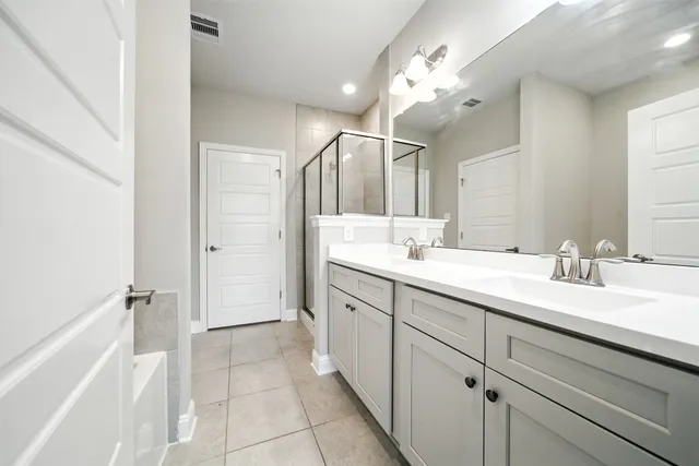 a spacious bathroom with a double vanity sink mirror and double