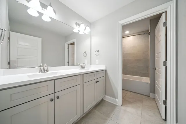 a spacious bathroom with a bathtub shower sink double and mirror