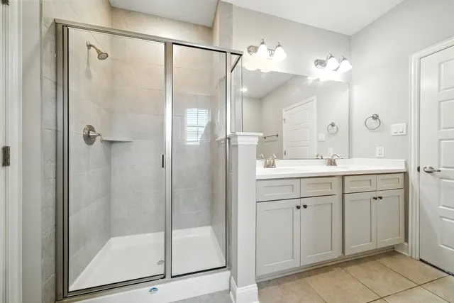 a bathroom with a shower sink and mirror