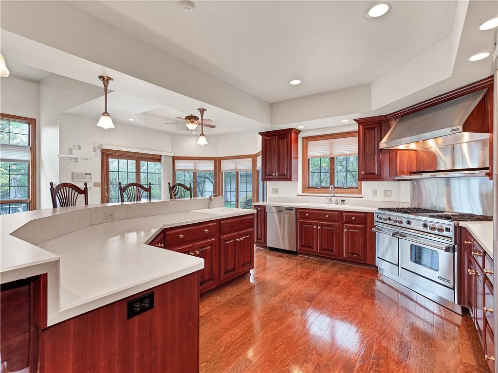 9290 Peebles Road Allison Park, PA 15101 - Photo 7 of 25 a large kitchen with stainless steel appliances granite countertop a stove a sink dishwasher and a dining table with wooden floor