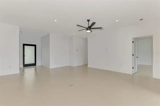 an empty room with a ceiling fan and a window