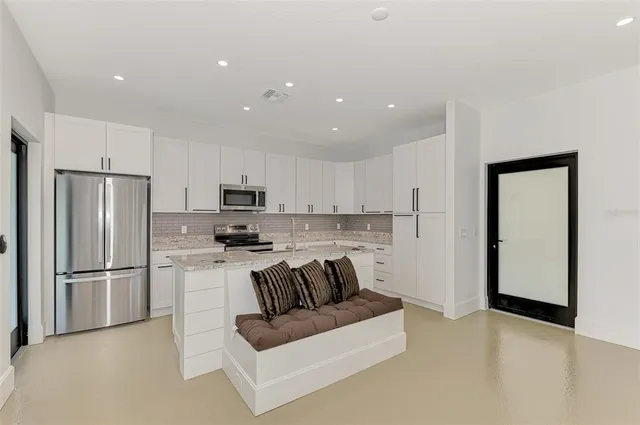 a kitchen with a refrigerator and a stove top oven