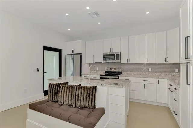 a kitchen with stainless steel appliances a refrigerator sink and stove