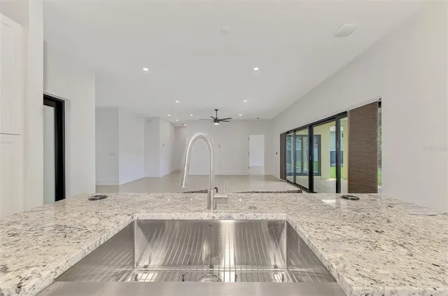 a view of a kitchen with kitchen island a sink appliances and a counter top space