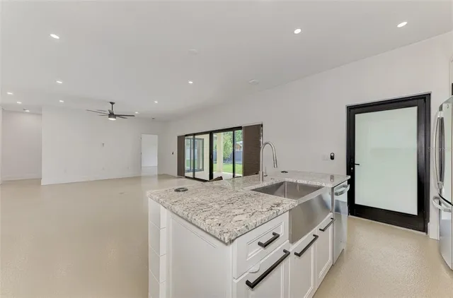 a bathroom with a granite countertop sink and a bathtub