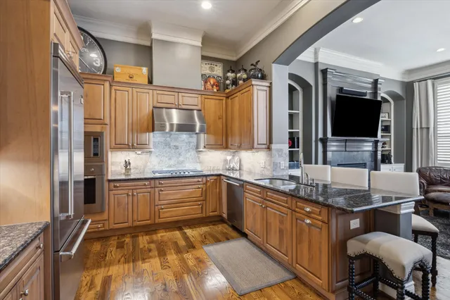 a kitchen with stainless steel appliances granite countertop a sink and a stove