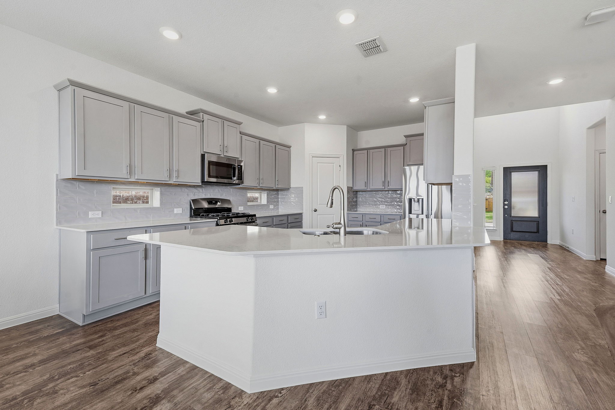 609 Allende Bend, Unit 130 Austin, TX 78748 - Photo 2 of 33 a kitchen with stainless steel appliances granite countertop a refrigerator a stove top oven a sink and white cabinets with wooden floor