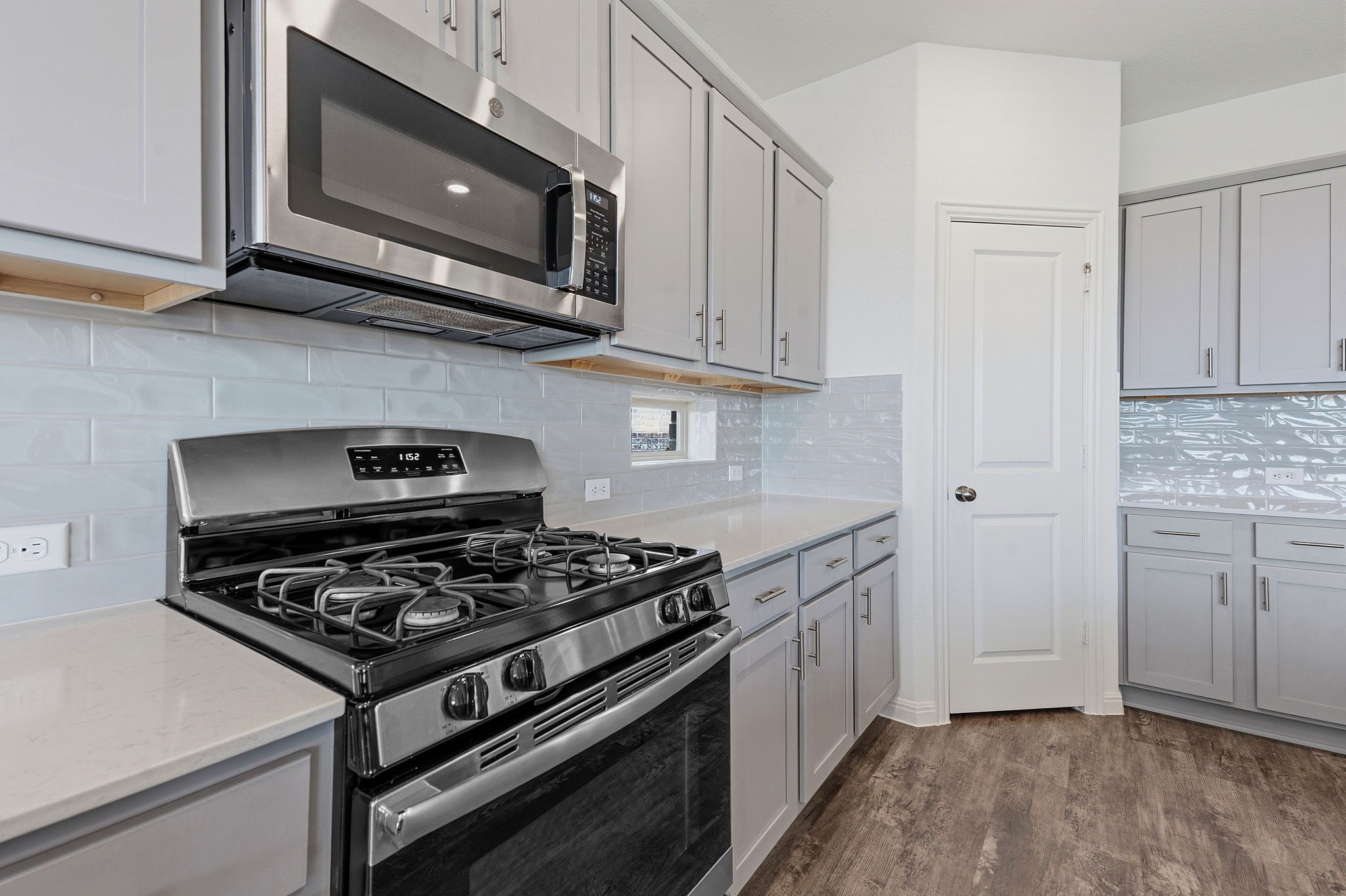 609 Allende Bend, Unit 130 Austin, TX 78748 - Photo 8 of 33 a kitchen with stainless steel appliances granite countertop grey cabinets a stove a sink and dishwasher