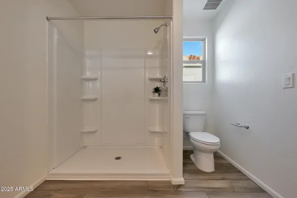 a bathroom with a shower a toilet and a shower