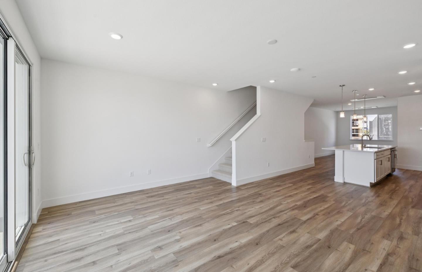 1357 Lilac Way Milpitas, CA 95035 - Photo 47 of 62 an empty room with wooden floor and a kitchen