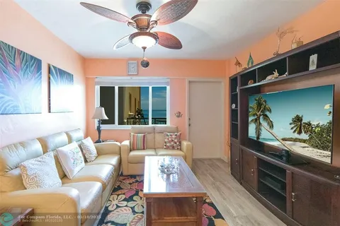 a living room with furniture a chandelier and a dining table