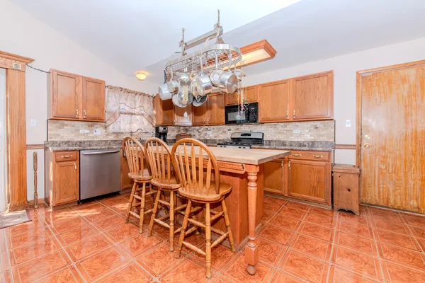 a room with stainless steel appliances kitchen island granite countertop furniture and a kitchen view