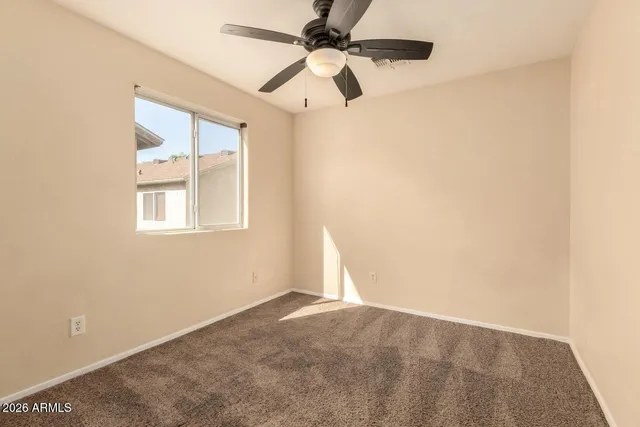 an empty room with windows and fan