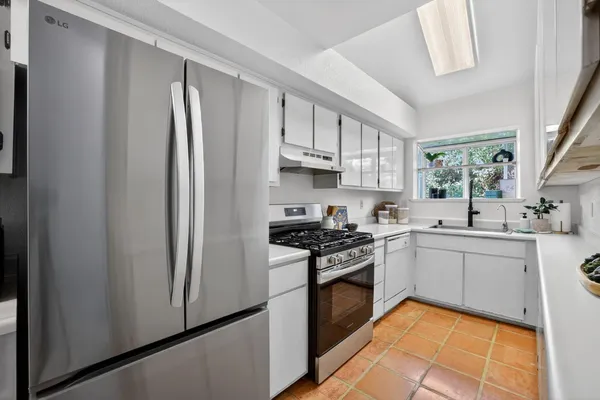 a kitchen with stainless steel appliances granite countertop a stove a sink and a refrigerator