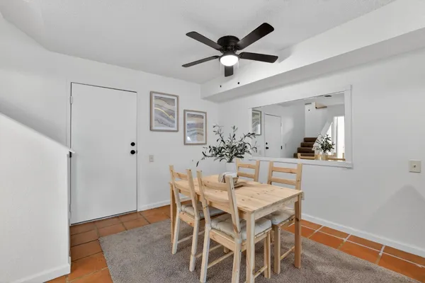 a view of a dining room with furniture and a chandelier fan