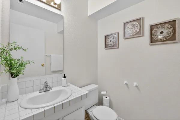 a bathroom with a toilet sink and mirror