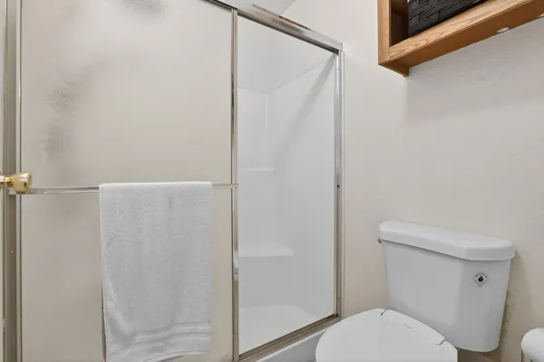 a white toilet sitting next to a shower