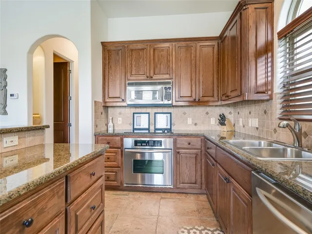 a kitchen with stainless steel appliances granite countertop a stove and a sink