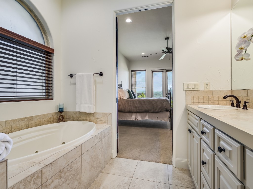 17545 West Reed Park Road, Unit 5 Jonestown, TX 78645 - Photo 17 of 26 a spacious bathroom with a tub sink and mirror