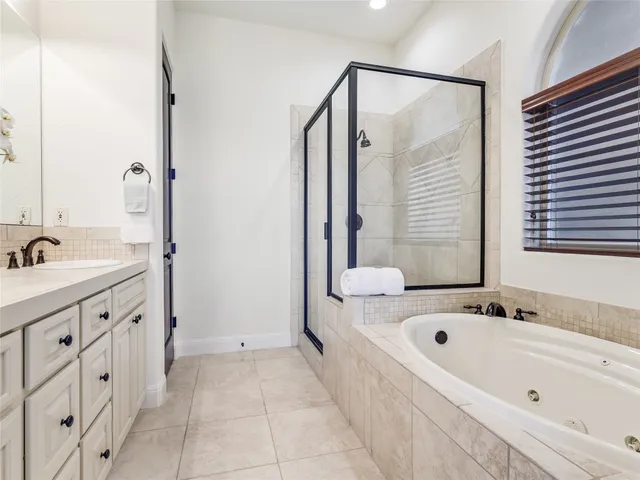 a bathroom with a tub sink and mirror