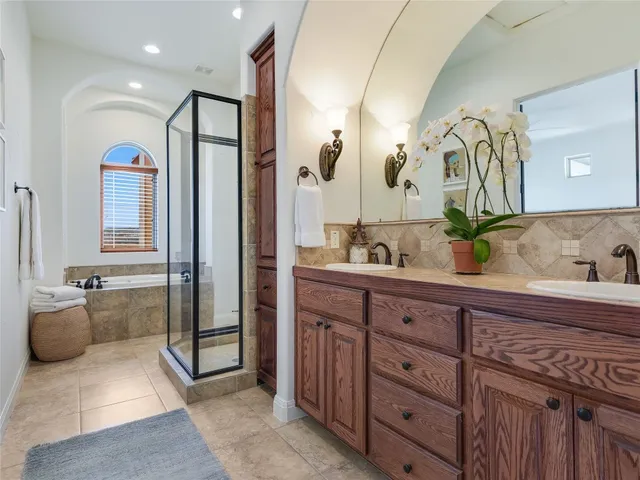 a spacious bathroom with a granite countertop sink mirror and bathtub