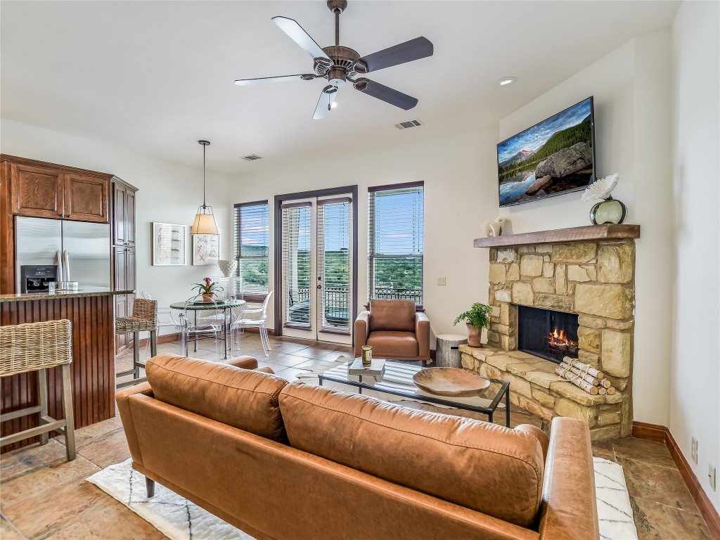 17545 West Reed Park Road, Unit 5 Jonestown, TX 78645 - Photo 6 of 26 a living room with fireplace furniture and a flat screen tv