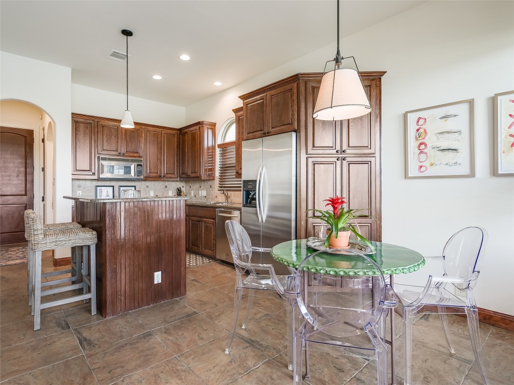 17545 West Reed Park Road, Unit 5 Jonestown, TX 78645 - Photo 10 of 26 a kitchen with stainless steel appliances granite countertop a refrigerator a stove and a wooden floors