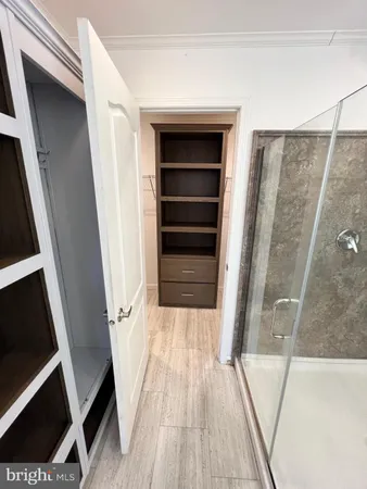 a view of walk in closet with wooden floor and staircase