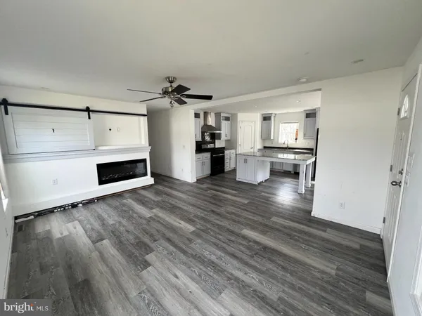 a view of a kitchen with wooden floor and electronic appliances