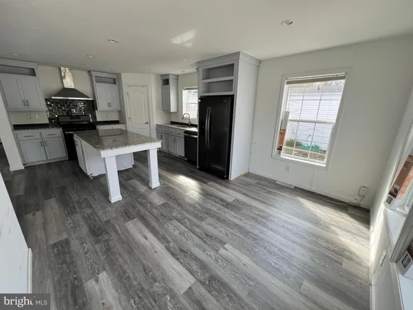 a kitchen with a refrigerator and a stove top oven