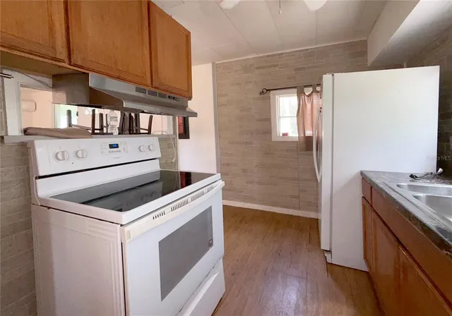 a kitchen with a stove and a wooden floors