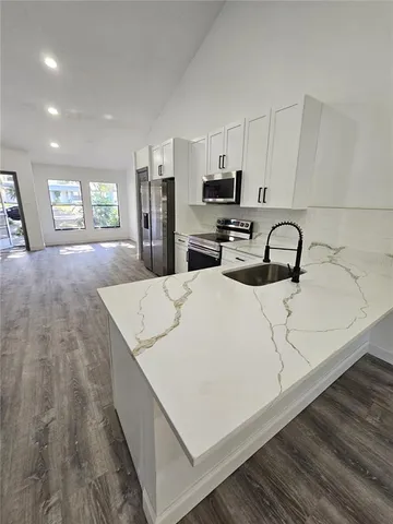 a kitchen with a sink a counter top space stainless steel appliances and cabinets