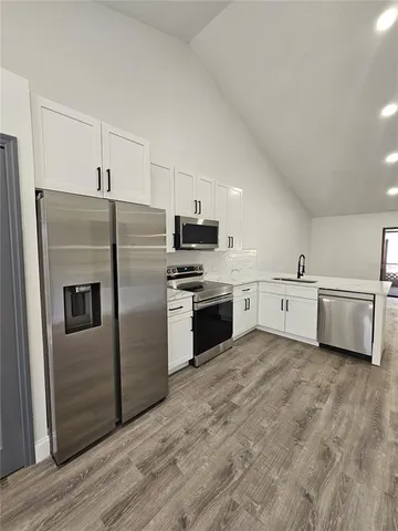 a kitchen with stainless steel appliances a refrigerator sink and cabinets