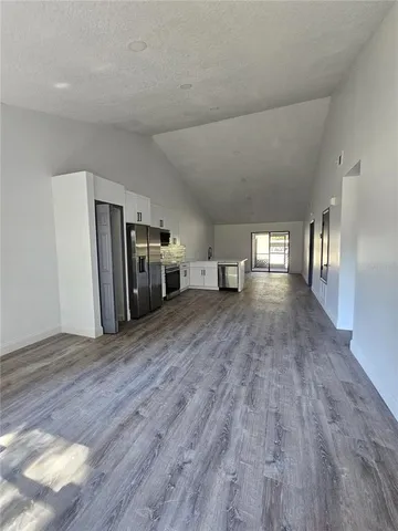 a view of a livingroom with a furniture wooden floor ceiling fan and windows