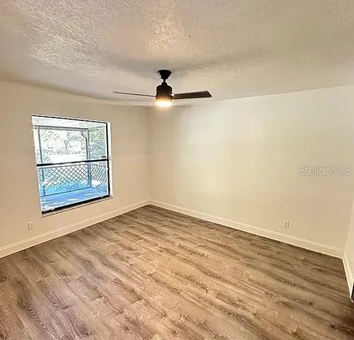 wooden floor in an empty room with a window