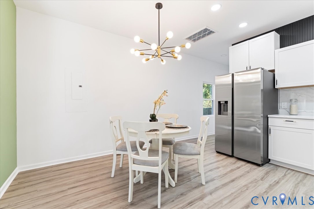 731 Harding Street Petersburg, VA 23803 - Photo 13 of 44 a view of a dining room with furniture a chandelier and wooden floor