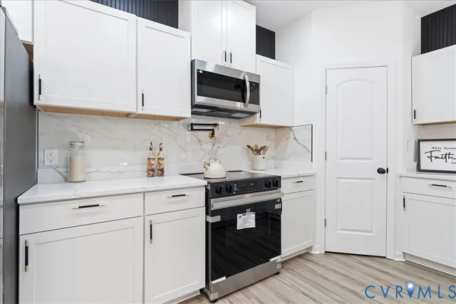 a kitchen with stainless steel appliances granite countertop white cabinets stove a sink and dishwasher