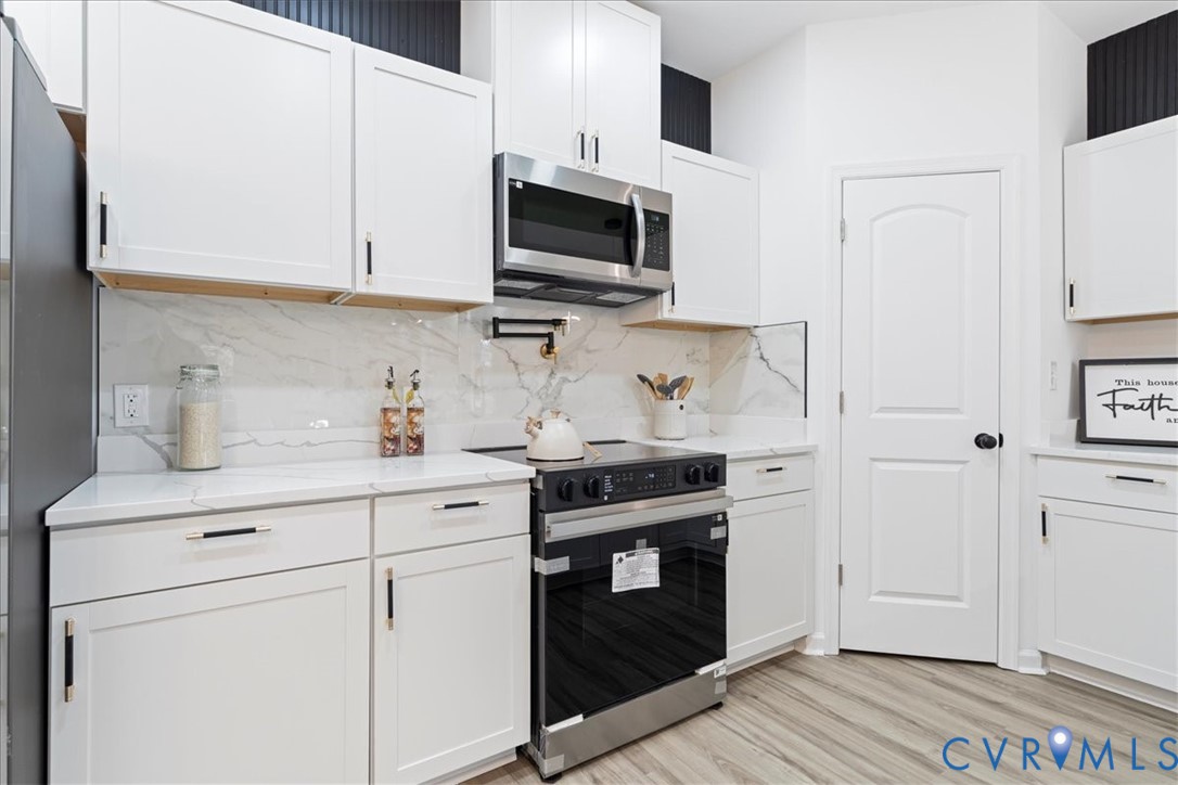 731 Harding Street Petersburg, VA 23803 - Photo 14 of 44 a kitchen with stainless steel appliances granite countertop white cabinets stove a sink and dishwasher