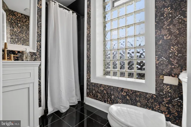 a bathroom with a toilet and a shower curtain