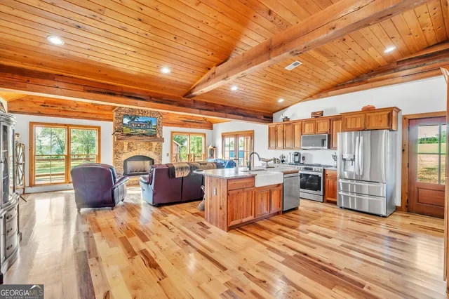 a large room with stainless steel appliances wooden floors and large windows