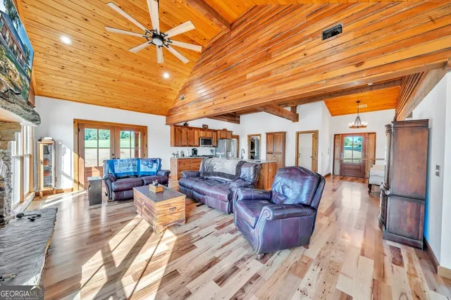 a view of a dining hall with stainless steel appliances wooden floor and chandelier