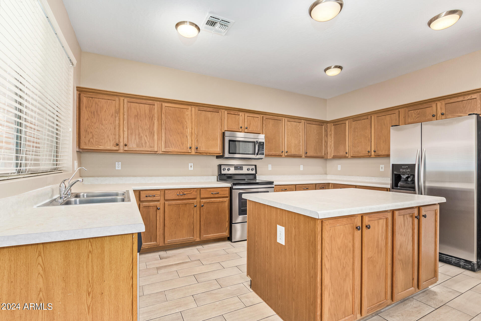 504 North Swallow Lane Gilbert, AZ 85234 - Photo 13 of 54 a kitchen with stainless steel appliances granite countertop a sink stove refrigerator and cabinets