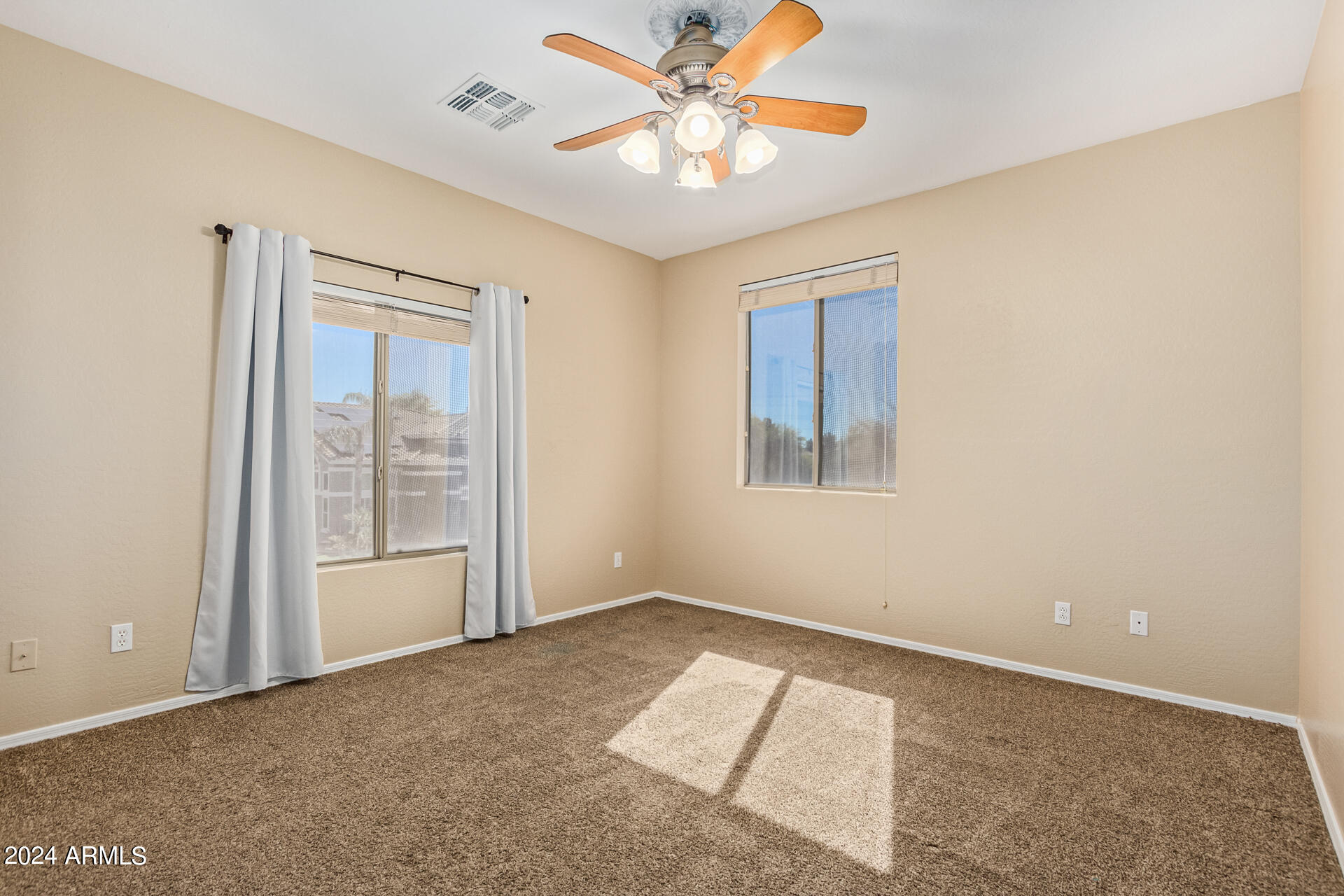 504 North Swallow Lane Gilbert, AZ 85234 - Photo 19 of 54 an empty room with chandelier fan and windows