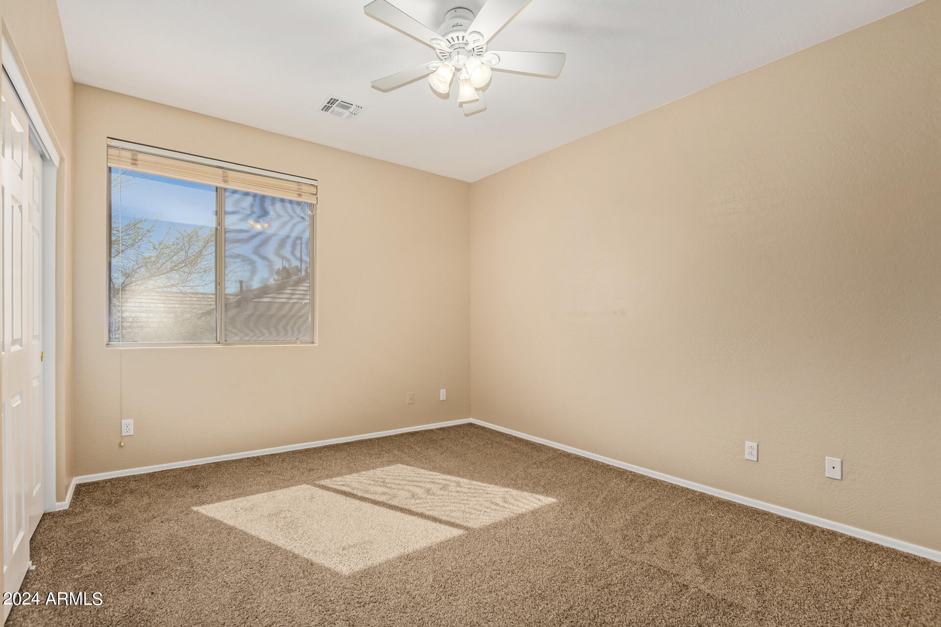 504 North Swallow Lane Gilbert, AZ 85234 - Photo 22 of 54 an empty room with a chandelier fan and windows