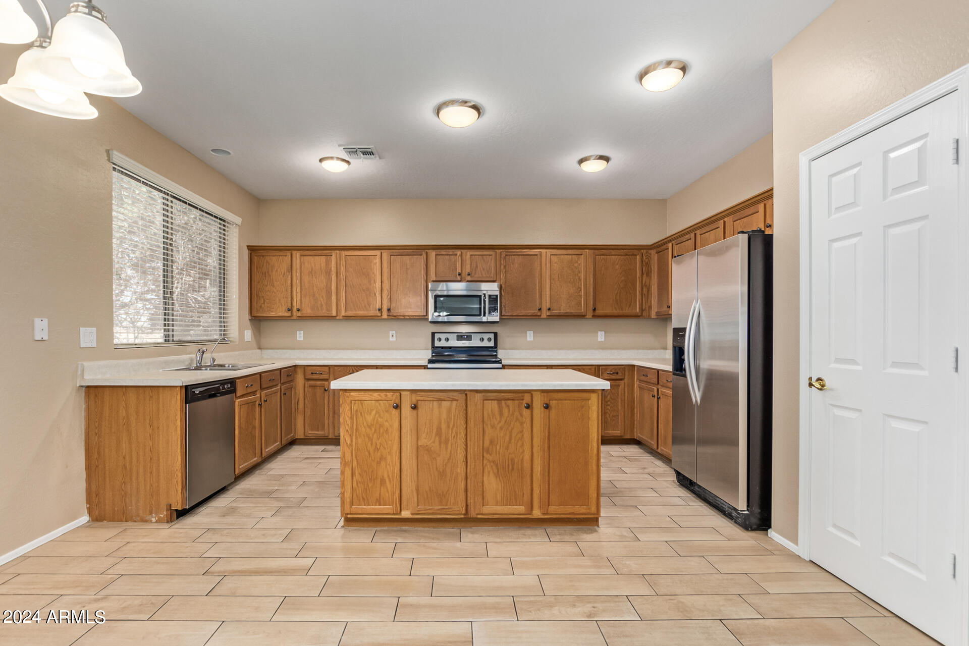 504 North Swallow Lane Gilbert, AZ 85234 - Photo 43 of 54 a kitchen with stainless steel appliances granite countertop a refrigerator a sink a stove a microwave and a dining table with wooden floor