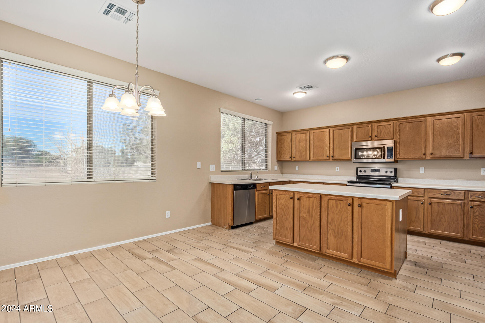 504 North Swallow Lane Gilbert, AZ 85234 - Photo 44 of 54 a kitchen with stainless steel appliances granite countertop a stove a sink and a refrigerator