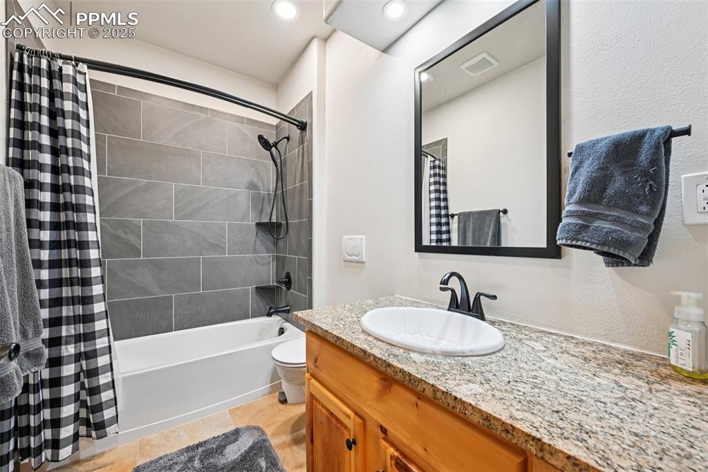 1417 Forest Road Manitou Springs, CO 80829 - Photo 45 of 50 a bathroom with a granite countertop sink a mirror a vanity and bathtub